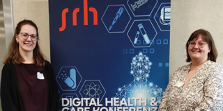 Leevke Wilkens (rechts) und Miriam Bursy (rechts) stehen vor einem Roll-Up der Digital Health & Care Konferenz