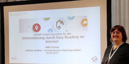 Miriam Wüst steht neben einer Leinwand, auf der das Thema des Workshops vom EVE4all Projekt zu sehen ist.