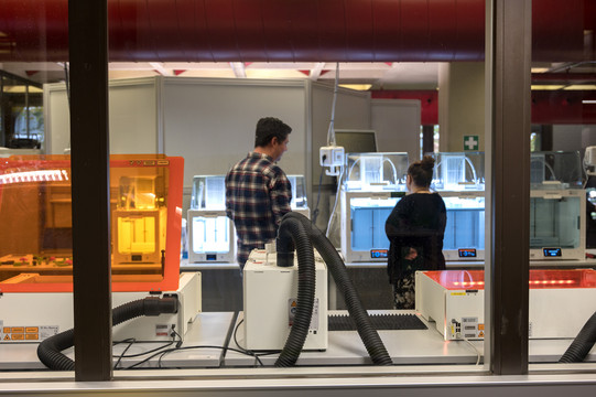 Zwei Personen stehen im Hylec vor einem 3D Drucker. Weitere technische Geräte im Vordergrund.