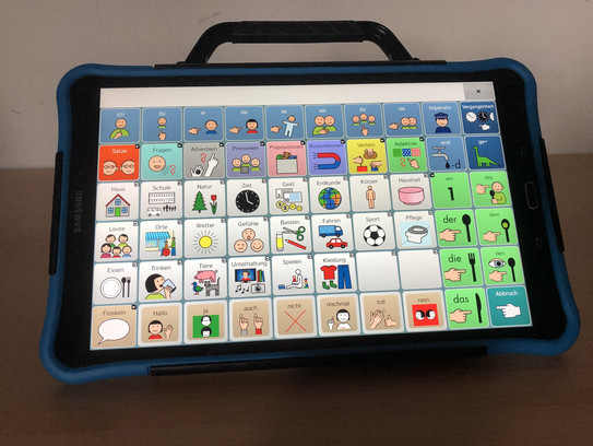 Samsung Tablet mit farbiger Schutzhülle, Tragegriff und Aufstellbügel. Auf dem Touchscreen sind verschiedene Symbole und ein Textfeld. 