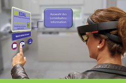 Eine weibliche Person trägt eine HoloLens und drückt auf ein Symbol eines Hologramms, um einen Lerninhalt auszuwählen