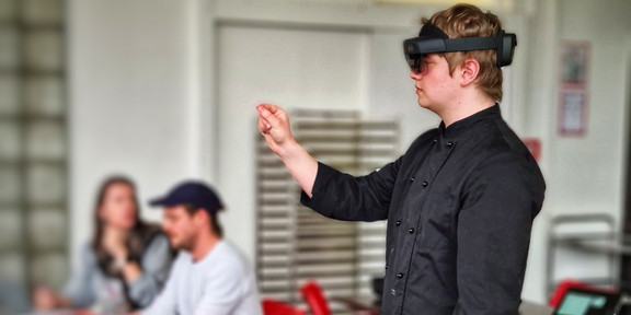 Junger Mann mit HoloLens führt eine Handgeste aus